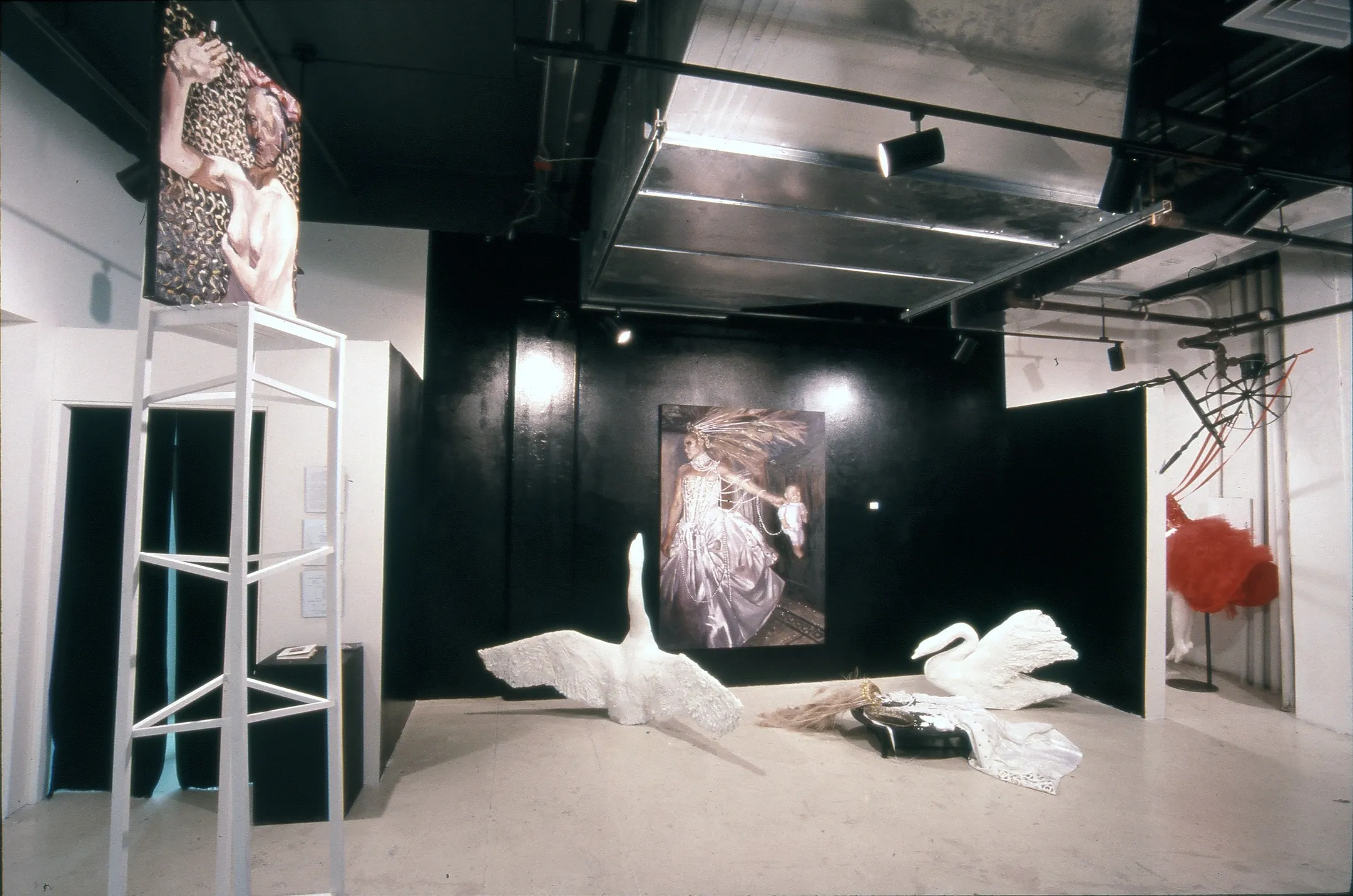 David's thesis exhibition at Lesley — large-scale portraits, white sculpted swans, and a costumed figure in red, installed in a black and white gallery